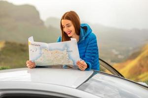 viajante com mapa turístico perto do carro foto