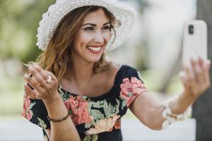 mulher fazendo selfie com seu smartphone enquanto desfruta de um dia de verão foto