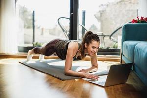 mulher fazendo treino online em casa foto