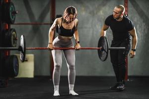 mulher exercitando com personal trainer na academia foto