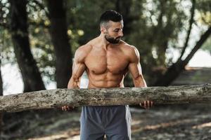 homem fazendo treinamento ao ar livre com madeira foto