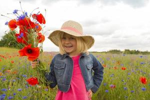 menina feliz com um buquê de flores silvestres. foto