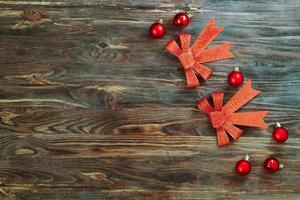 arcos vermelhos e lenços de natal em um fundo de madeira, copie o espaço foto