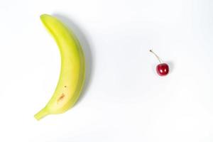 banana e cereja no fundo branco foto