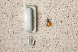 chaves do apartamento e interfone branco na parede do apartamento. foto