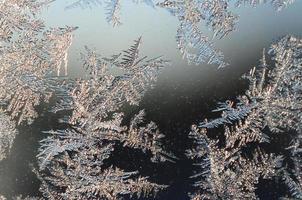 macro de geada de flocos de neve no painel de vidro da janela foto