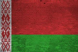 bandeira da bielorrússia retratada em cores de tinta na parede de tijolos antigos. banner texturizado em fundo de alvenaria de parede de tijolo grande foto