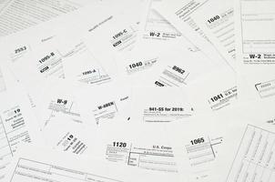 muitos espaços em branco do formulário de imposto encontram-se na mesa de perto. rotina de papelada de contribuintes e conceito de burocracia foto