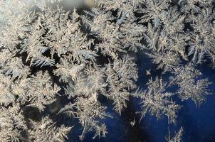 macro de geada de flocos de neve no painel de vidro da janela foto