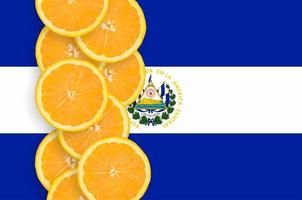 bandeira de el salvador e linha vertical de fatias de frutas cítricas foto