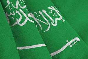 bandeira da arábia saudita com grandes dobras acenando de perto sob a luz do estúdio dentro de casa. os símbolos oficiais e cores no banner foto