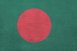 bandeira de bangladesh retratada em cores de tinta brilhante na parede de reboco em relevo antigo. banner texturizado em fundo áspero foto