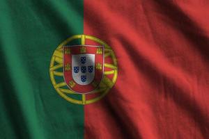 bandeira de portugal com grandes dobras acenando de perto sob a luz do estúdio dentro de casa. os símbolos oficiais e cores no banner foto