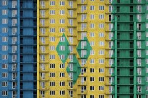 bandeira de são vicente e granadinas retratada em cores de tinta em prédio residencial de vários andares em construção. banner texturizado no fundo da parede de tijolos foto