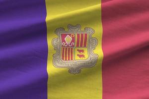 bandeira de andorra com grandes dobras acenando de perto sob a luz do estúdio dentro de casa. os símbolos oficiais e cores no banner foto