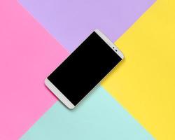 smartphone moderno com tela preta no fundo de textura de papel de cores pastel de moda azul, amarelo, violeta e rosa em conceito mínimo foto