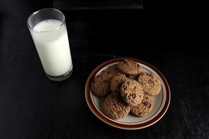 biscoitos e leite em fundo preto. espaço para texto foto