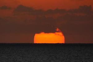 disco solar subindo no horizonte do mar, nascer do sol, amanhecer foto