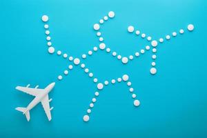modelo branco de um avião de passageiros com pontos de trajetória pontilhada isolados no fundo. a rota da aeronave nos países e no céu. foto