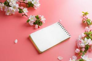 sakura de primavera florescendo em um fundo rosa com espaço de bloco de notas para mensagem de saudação. o conceito de primavera e dia das mães. lindas flores delicadas de cerejeira rosa na primavera foto