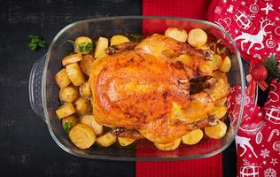 peru ou frango assado. a mesa de natal é servida com um peru decorado com enfeites brilhantes. frango frito, mesa. ceia de Natal. vista de cima, acima foto