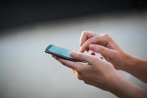 close-up das mãos das mulheres segurando o telefone celular com tela de espaço de cópia em branco para sua mensagem de texto de publicidade ou conteúdo promocional foto