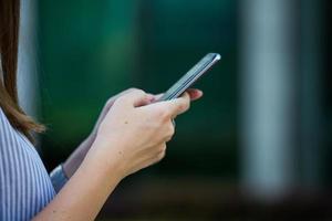 close-up das mãos das mulheres segurando o telefone celular com tela de espaço de cópia em branco para sua mensagem de texto de publicidade ou conteúdo promocional foto