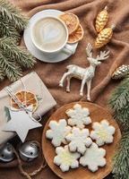 uma xícara de café com leite, biscoitos caseiros e bolas de natal e suéter de malha. foto