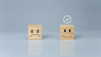 o sinal correto está em um bloco de madeira com um ícone sorridente. representa avaliação de feedback e avaliação positiva do cliente, conceito de satisfação, pesquisa de satisfação, pense no conceito positivo foto