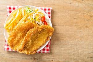 peixe e batatas fritas com mini salada foto