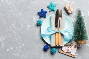 composição de férias do jantar de natal em fundo de cimento. vista superior do prato, utensílio e decorações festivas. conceito de advento de ano novo com espaço de cópia foto
