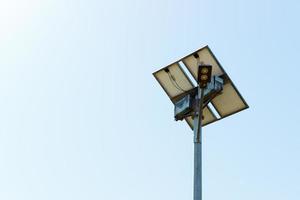 lâmpada de rua com painel de célula solar no fundo do céu azul foto