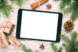 tablet digital simulado com decorações rústicas de fundo vintage de madeira rústica de natal para apresentação de aplicativos. vista superior com espaço de cópia foto