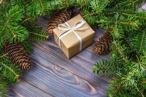 árvore de natal com caixa de presente e decorações no espaço de fundo de madeira para letras foto