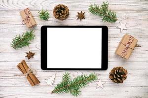 tablet digital simulado com vintage rústico, decorações de fundo de madeira de natal em tons para apresentação de aplicativos. vista superior com espaço de cópia foto