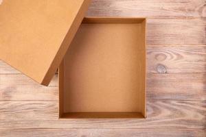 caixa de papelão aberta sobre uma mesa de madeira. vista do topo foto