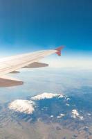 vista da janela do avião que voa sobre as montanhas foto