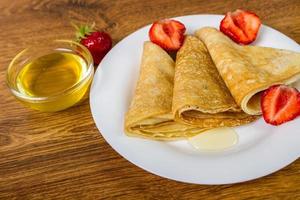 pilha de crepes com calda de morango e mel foto