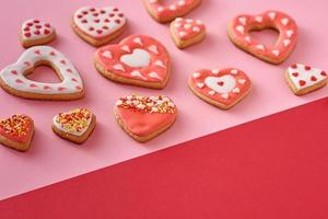 biscoitos decorados em forma de coração em um fundo colorido vermelho e rosa, vista superior foto