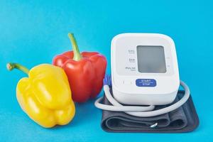monitor digital de pressão arterial e pimenta de legumes frescos foto