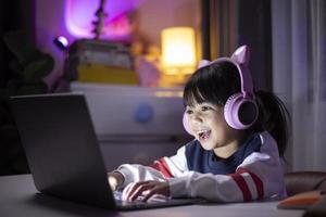 streamer de garota asiática jogando videogame com expressão de vencedor na sala de jogos.