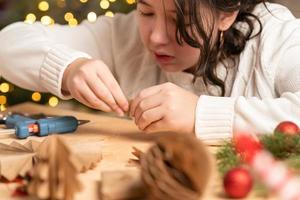 garota faz enfeites de árvore de natal sem papel com as próprias mãos. instrução passo a passo foto