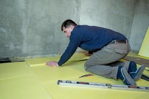 instalação de poliestireno expandido na sala para isolamento de piso, trabalho de reparo sozinho, poliestireno expandido amarelo. foto