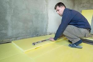 instalação de poliestireno expandido na sala para isolamento de piso, trabalho de reparo sozinho, poliestireno expandido amarelo. foto