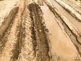 textura de uma estrada de terra suja e ruim com poças e lama de secagem de argila com rachaduras e sulcos. fora da estrada. o fundo foto