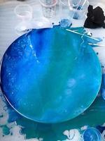 o processo de criação de um padrão moderno abstrato moderno feito em casa pintado com um pincel de resina multicolorida azul acrílica em um javali de madeira redondo foto