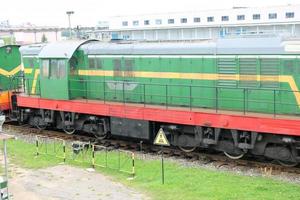 trem de carga com rodas de ferro metálico verde, locomotiva para o transporte de mercadorias nos trilhos da estação ferroviária foto