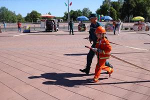 o homem de um bombeiro está ensinando uma garotinha em um traje à prova de fogo teimoso a correr com mangueiras para extinguir os poros bielorrússia, minsk, 08.08.2018 foto