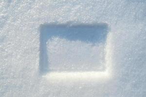 impressão de uma moldura retangular na neve, em um dia ensolarado de inverno. copie o espaço. foto