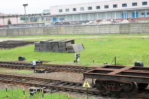 vagão de carga com rodas de ferro de metal enferrujado vazio para o trem, locomotiva para o transporte de mercadorias ao longo dos trilhos na estação ferroviária foto